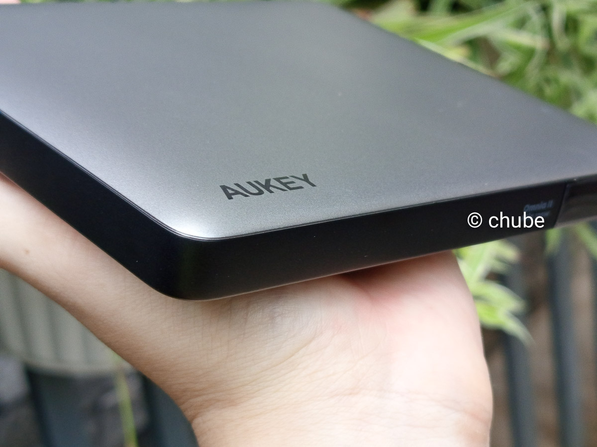 Logo Aukey và thiết kế pin dự phòng siêu mỏng màu bạc có thiết kế tương đương và cùng tông với màu của chiếc MacBook